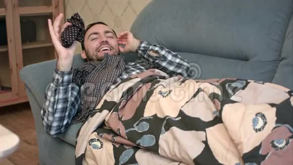 生病但乐观的男人躺在床上对着镜头说话视频的预览图