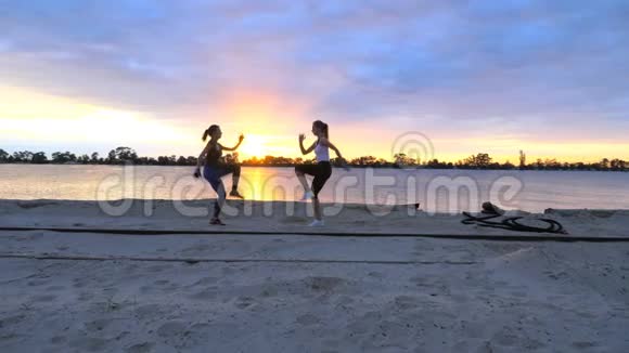 美丽苗条的年轻女性从事健身跳跃表演力量练习俯卧撑在黎明日出在视频的预览图