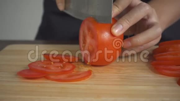 慢动作关闭首席女人做沙拉健康食品和切番茄在切割板在厨房视频的预览图
