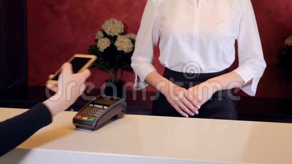 女士用智能手机支付酒店费用接待员给电子钥匙4K视频的预览图