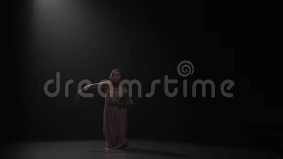 在聚光灯下在演播室里跳舞的女人慢动作视频的预览图