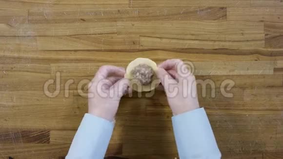 从上面的手做饺子在木桌上关于做饺子的俯视图饺子面粉韭菜擀面杖视频的预览图