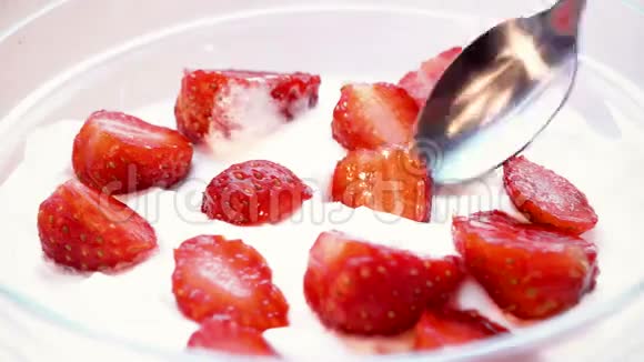 草莓是用勺子从奶油中取出的一次宏观射击时光流逝视频的预览图