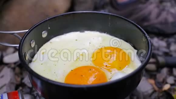 在露营炉上用平底锅煎蛋视频的预览图