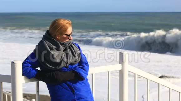 一个戴着太阳镜的女孩站在海滨看暴风雨视频的预览图