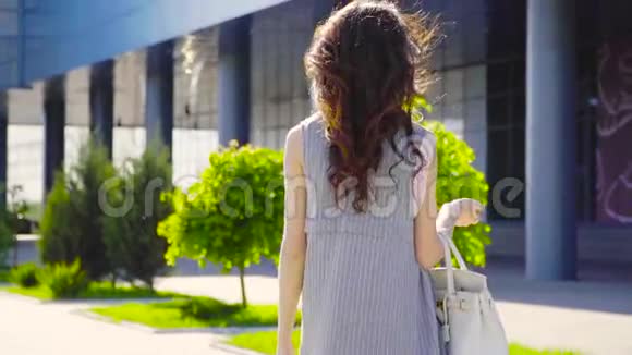 带手提包的时尚女士靠近商务中心视频的预览图