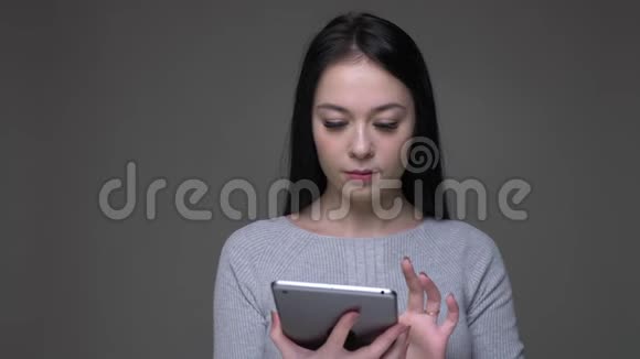 年轻漂亮的棕色白种人女性使用平板电脑特写镜头并显示绿色彩色屏幕与相机视频的预览图