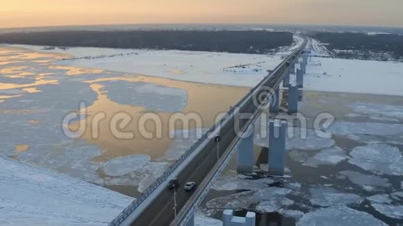 空中跟踪拍摄单人车在冬季河上的桥上浮冰视频的预览图