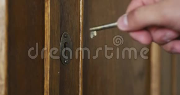 古玩木柜钥匙孔里的人手一把把旧钥匙视频的预览图