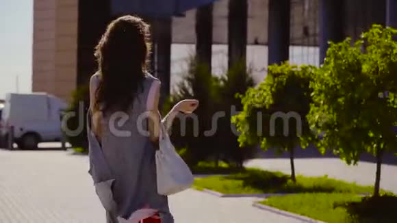 带手提包的时尚女士靠近商务中心视频的预览图
