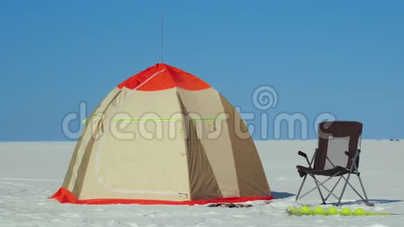 冬天的帐篷椅子和冰钻在冰冻的湖面上钓鱼捕鱼设备视频的预览图