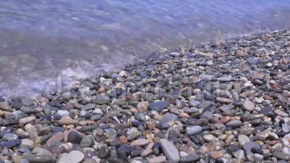 海上冲浪波浪在海岸岩石上流动卵石上的波浪在靠近视频的预览图