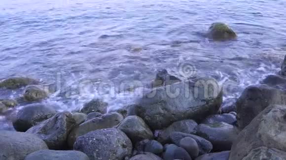 海上冲浪波浪在海岸岩石上流动卵石上的波浪在靠近视频的预览图