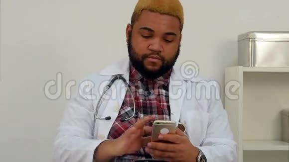 非裔美国男性医生检查他的电话和填写表格视频的预览图