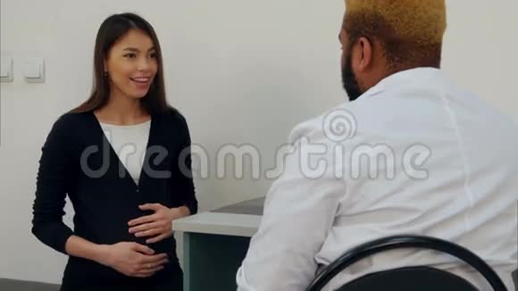 快乐的年轻孕妇与男医生进行产前检查视频的预览图