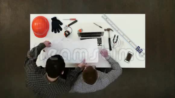 两个男建筑师讨论图纸和蓝图视频的预览图