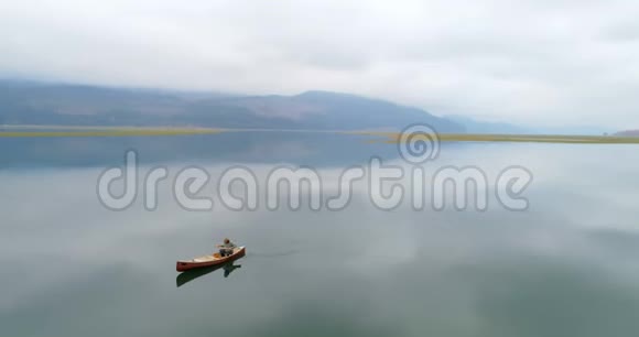人与狗在湖上划船视频的预览图