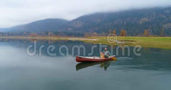 人与狗在湖上划船视频的预览图