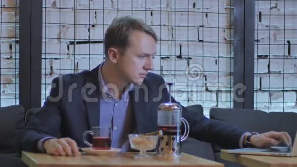 穿着服装的帅哥在现代咖啡馆喝茶视频的预览图