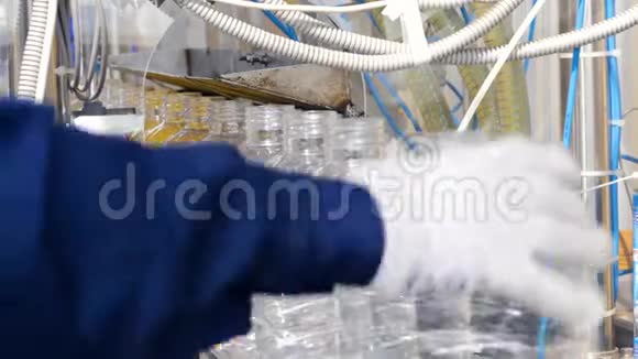 生产线上的塑料瓶工人把PET瓶放在传送带上4K视频的预览图