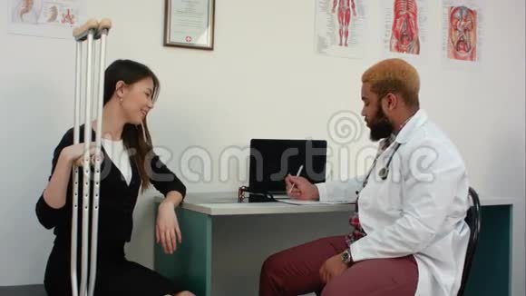 女性患者用拐杖与医生讨论病情视频的预览图