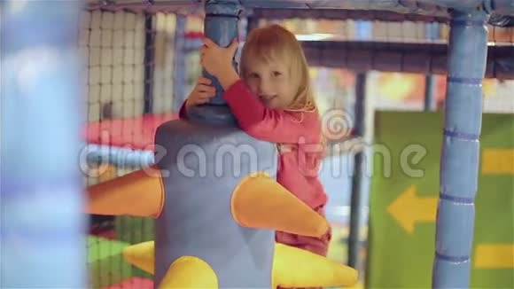 穿红色毛衣的小女孩在儿童游戏室里玩视频的预览图