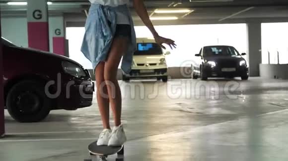 年轻时穿着休闲服的漂亮女人在停车场玩滑板视频的预览图