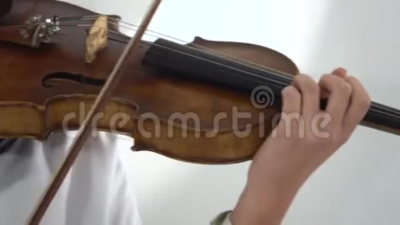 拉小提琴的女孩指着琴弦快关门白色背景视频的预览图