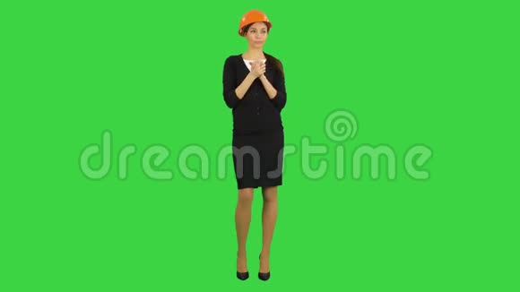 戴着安全帽的疲惫的年轻女子在绿色屏幕上打哈欠和伸展Chroma键视频的预览图