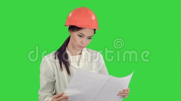 年轻的女建筑师拿着蓝图在绿色屏幕上检查建筑Chroma键视频的预览图