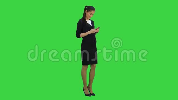 高兴的年轻女子受宠若惊在绿色屏幕上向她的手机发送了赞美Chroma键视频的预览图