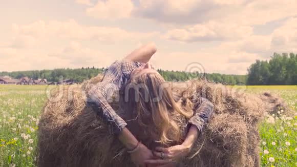夏天躺在干草堆上的年轻女子视频的预览图