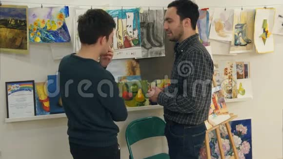 两个年轻人在讨论艺术学生画的画视频的预览图