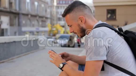 年轻人坐在城市的台阶上打电话视频的预览图