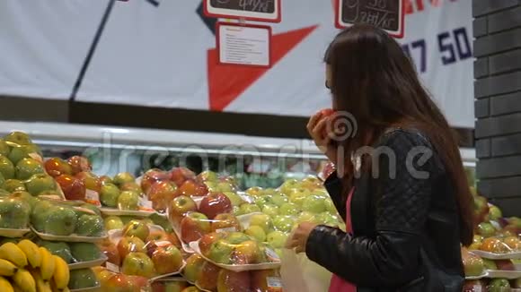 年轻女子在超市蔬菜部挑选水果视频的预览图
