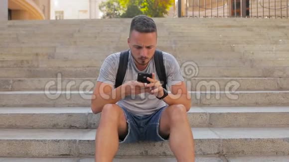 年轻人坐在城市的台阶上打电话视频的预览图