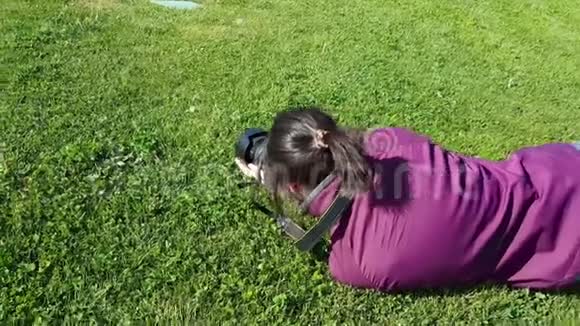 使用单反相机拍摄草地上的女性摄影师视频的预览图