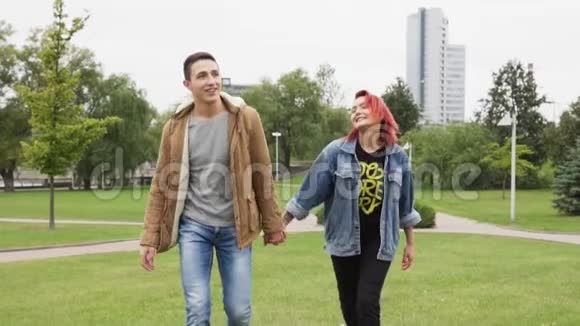 幸福的男人和女人牵着手在城市公园里散步视频的预览图