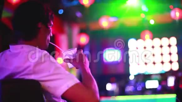 英俊的男人坐在酒吧里在一家夜总会里喝着鸡尾酒灯光很漂亮1920x1080视频的预览图