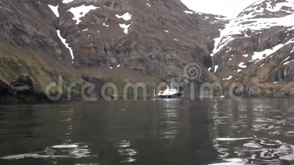 船靠近瀑布在岩石海岸和山福克兰群岛视频的预览图