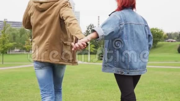 年轻夫妇牵着手在城市公园散步视频的预览图
