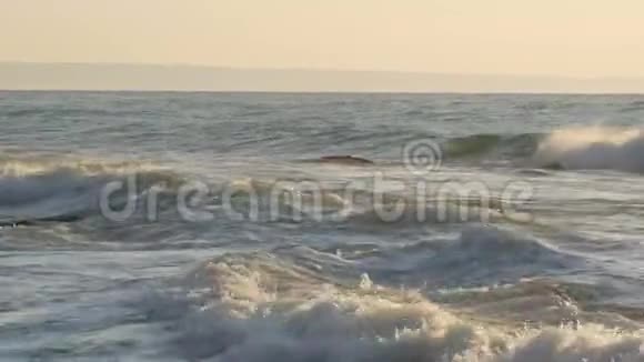 巨大的强波撞击到巨大的岩石中海上风暴大浪在岩石海岸上破碎白沫在水面上视频的预览图
