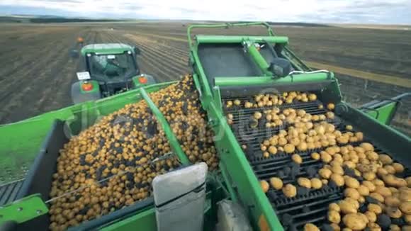 一辆带输送机移动土豆的拖拉机关门视频的预览图