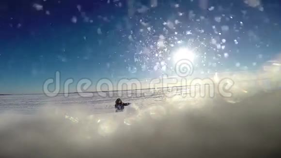 暴风雨中穿着冬衣的小男孩在雪地里犁地视频的预览图