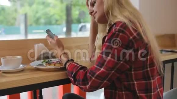 咖啡馆里有智能手机的年轻美女视频的预览图