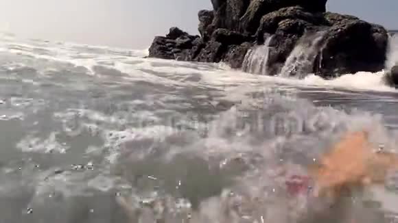 十几岁的男孩游泳爬上岩石视频的预览图
