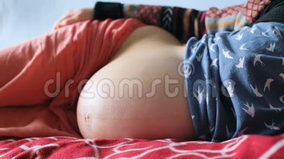 躺在一旁的孕妈小心翼翼地抚摸着肚子视频的预览图