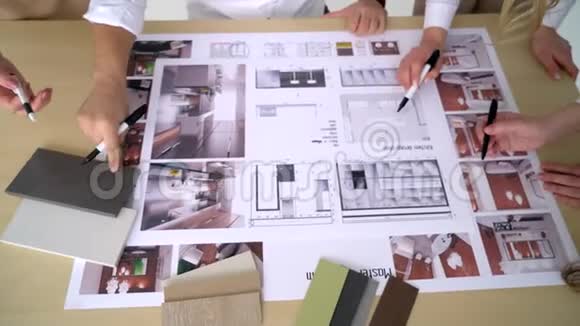四位建筑师在办公桌上讨论设计图的特写镜头视频的预览图