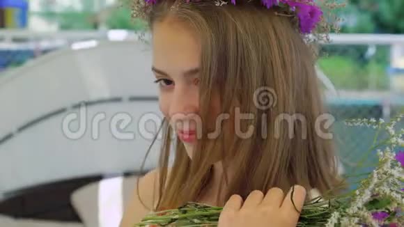 带着一束鲜花的无忧无虑的女孩子在风湾酒吧4K四处张望视频的预览图