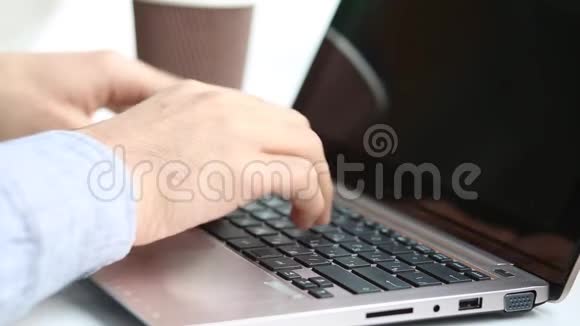 近距离观看一个男人在笔记本电脑上键盘和喝咖啡视频的预览图
